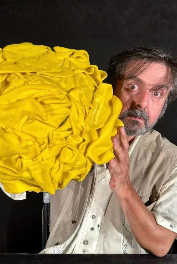 L'ATTORE TIENE UN GIGANTESCO GOMITOLO GIALLO TRA LE MANI