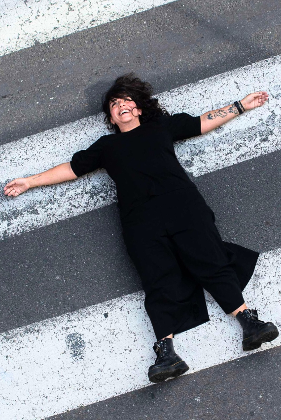 l'attrice distesa a braccia aperte sulle strisce pedonali