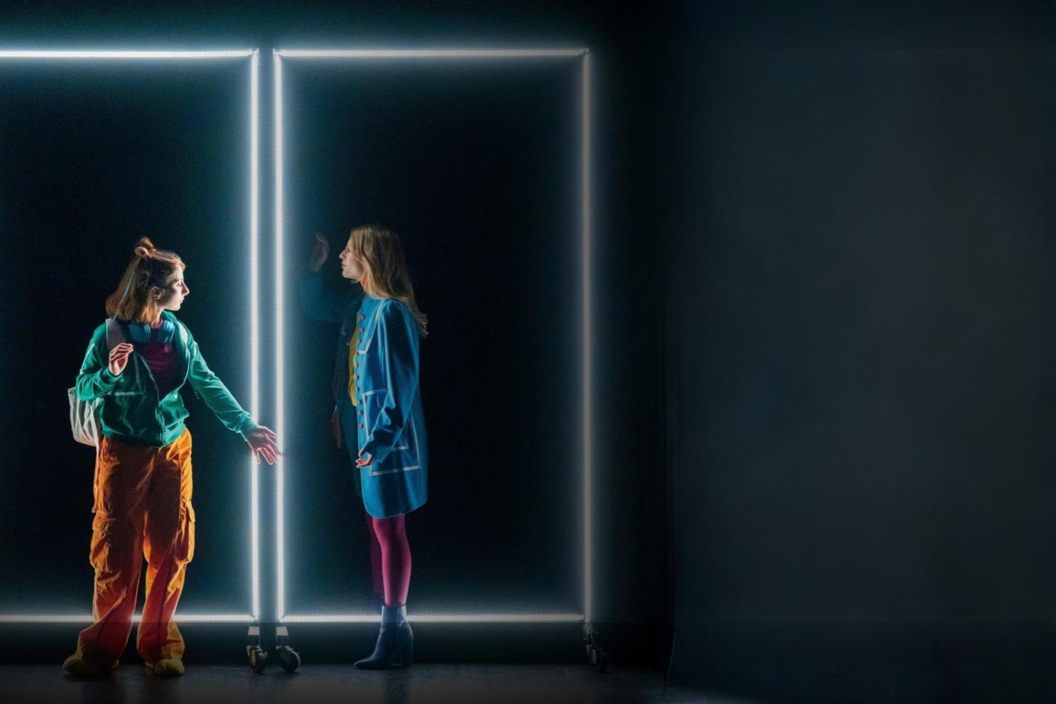due ragazze in una scena dominata da neon rettangolari bianchi