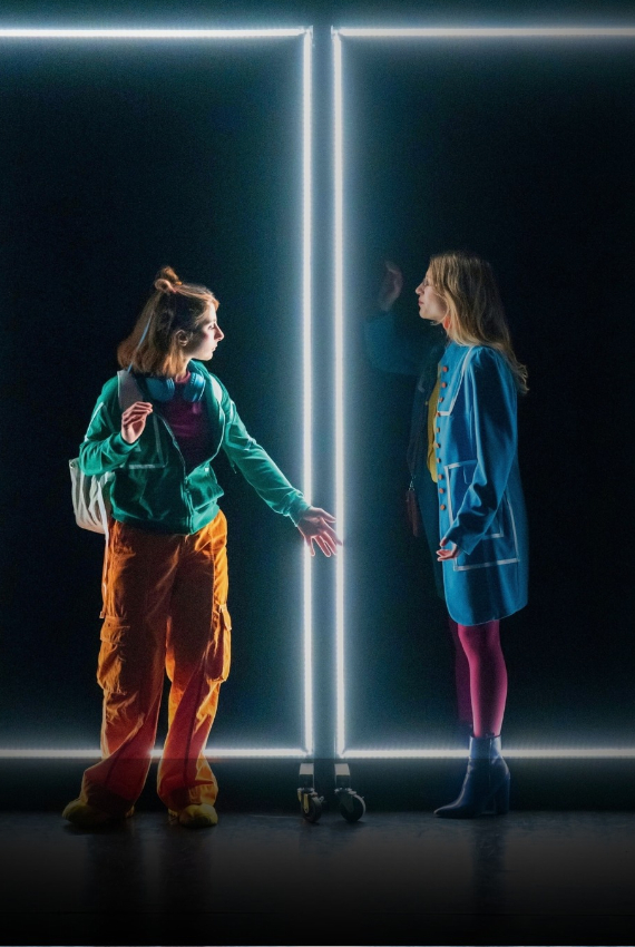 due ragazze in una scena dominata da neon rettangolari bianchi