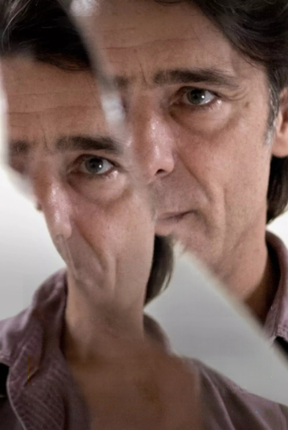 un uomo riflesso in uno specchio rotto