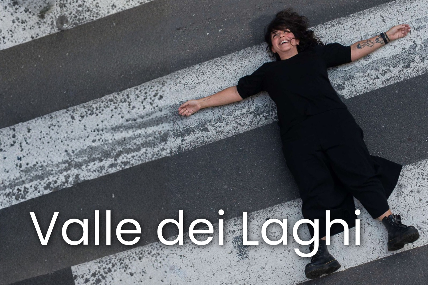 un'attrice a braccia aperte distesa sulla strada
