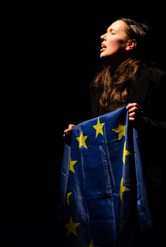 una donna piangente regge la bandiera europea