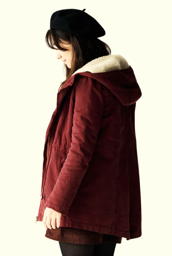 una ragazza in cappotto rosso di profilo